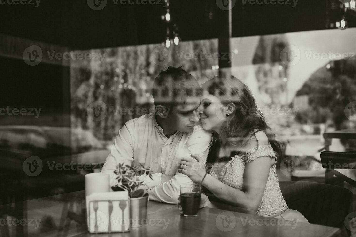côté vue portrait de une aimant européen couple en riant tandis que profiter une Date dans une café. noir et blanc photo