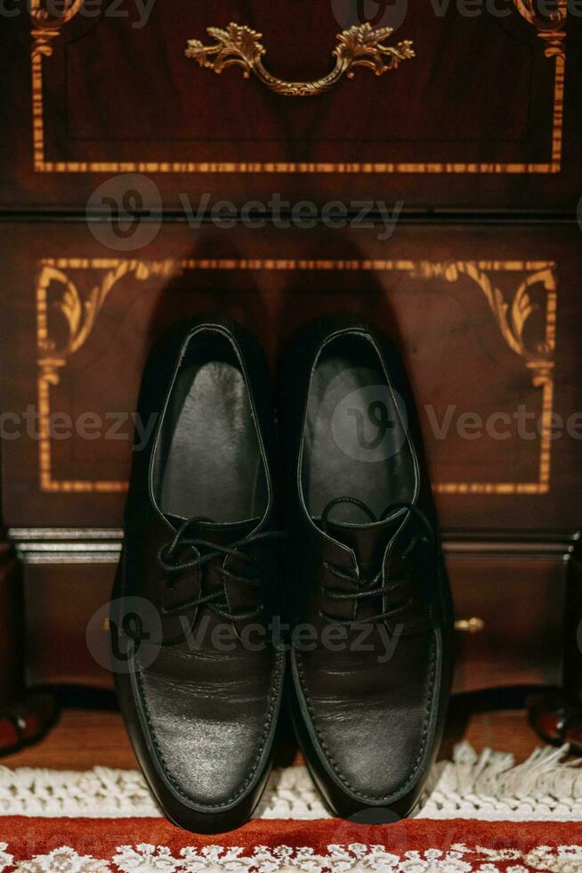 Pour des hommes noir cuir chaussures. accessoires sur le du marié mariage journée. photo