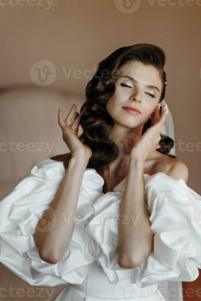 magnifique modèle fille avec longue frisé cheveux dans une à la mode mariage robe. verticale fermer portrait photo