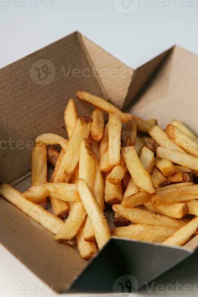 français frites dans une papier boîte sur une blanc Contexte fermer photo