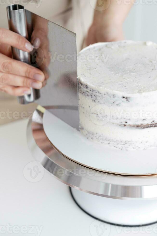 fermer de une femme décorer gâteau avec blanc Glaçage photo