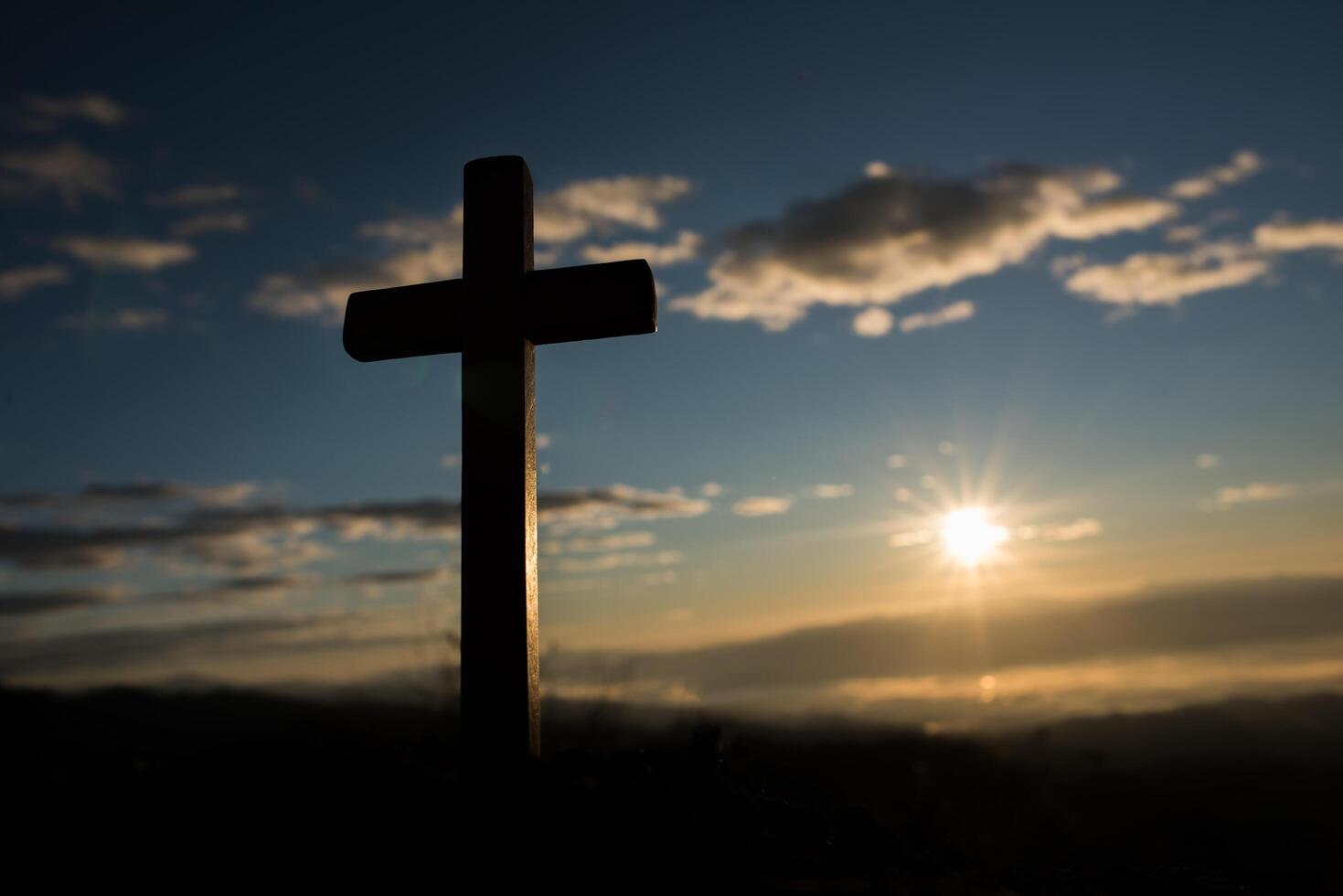 silhouette de croix catholique et lever de soleil photo