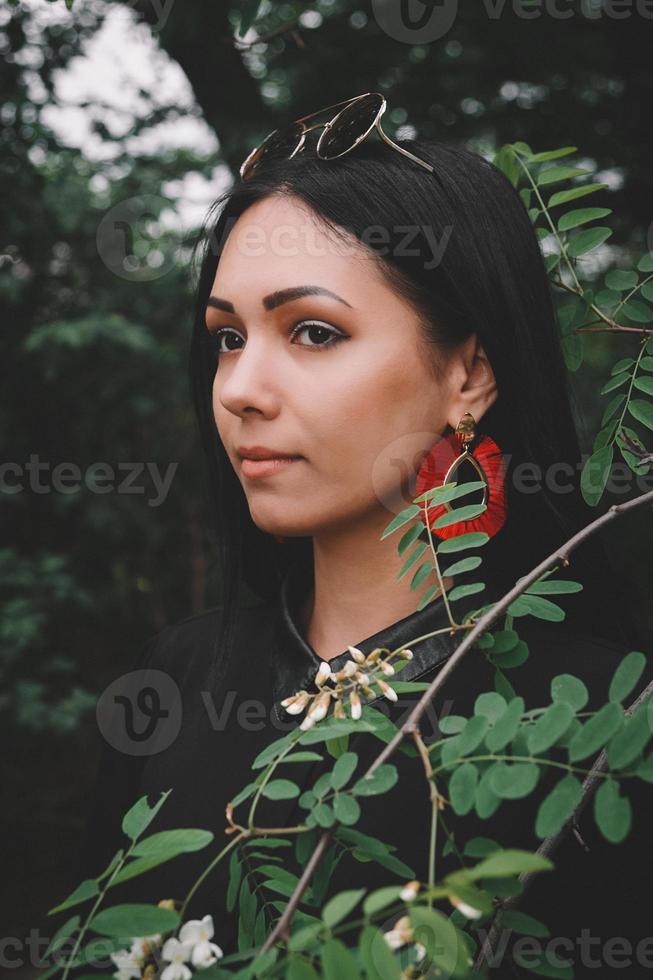 femme en robe noire et décorations rouges sur fond de forêt photo