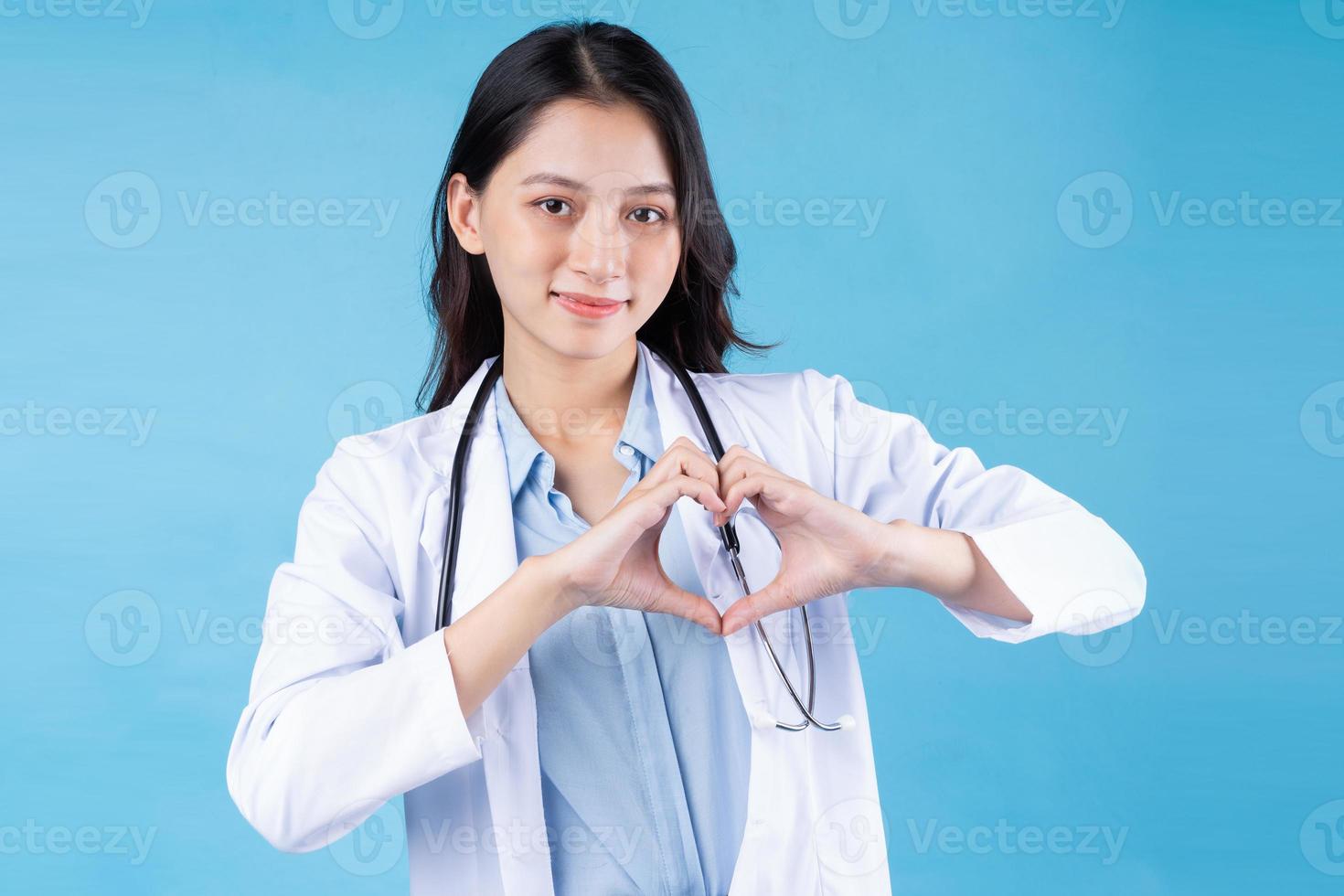 Portrait de jeune femme médecin, isolé sur fond bleu photo