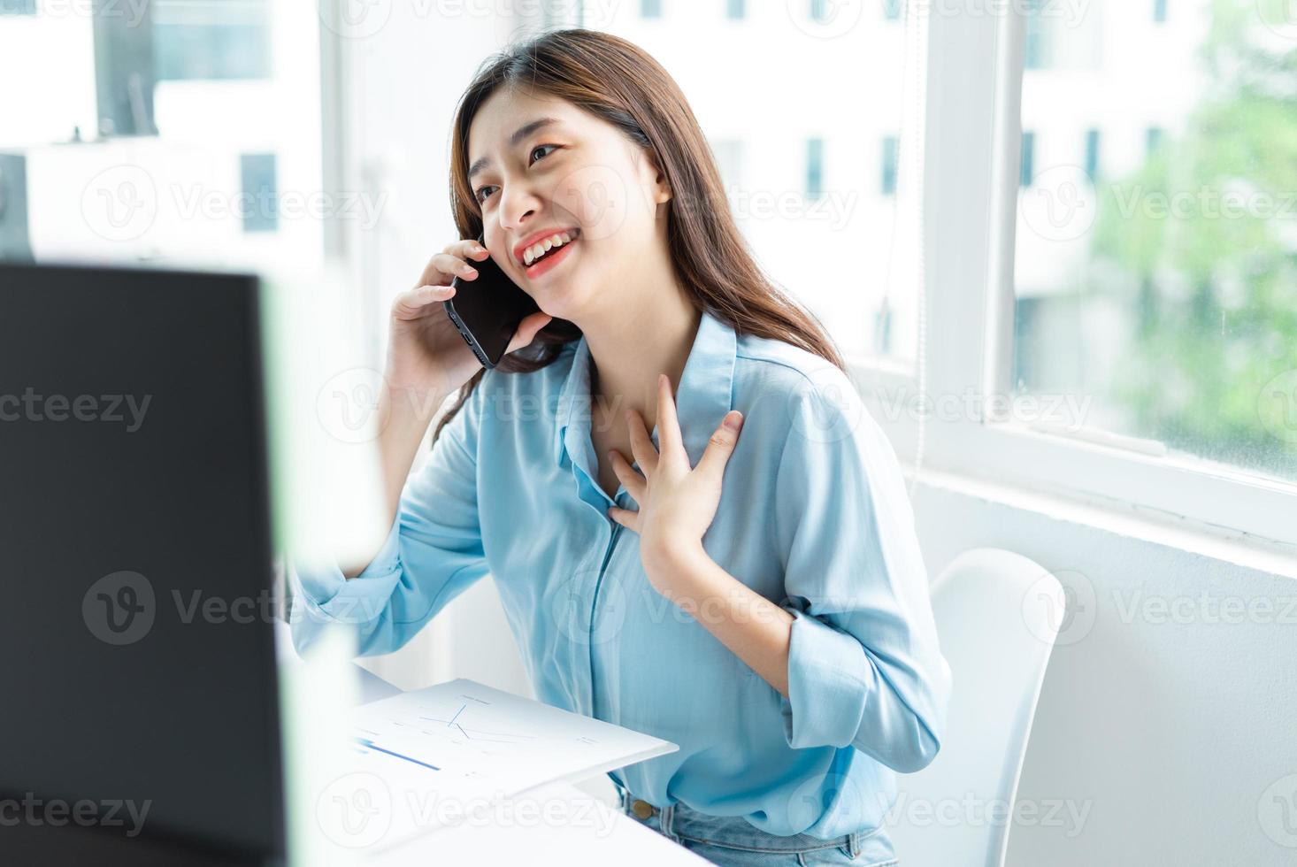 portrait de jeune femme d'affaires asiatique parlant joyeusement au téléphone photo