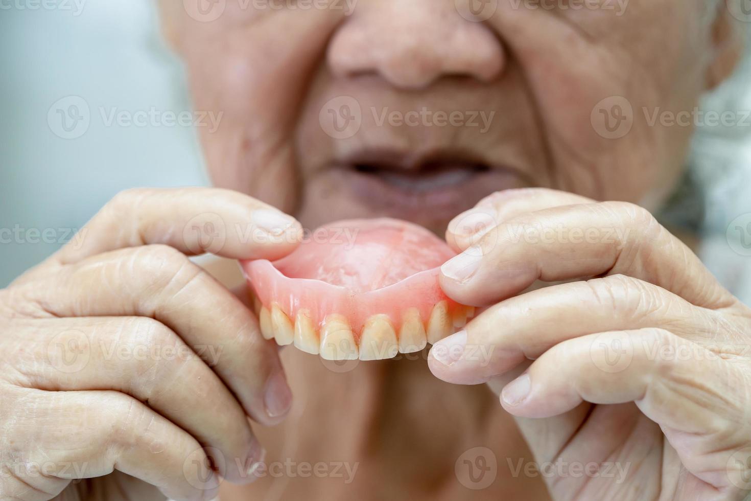 patiente asiatique âgée ou âgée tenant une prothèse dentaire dans un hôpital de soins infirmiers, concept médical solide et sain photo