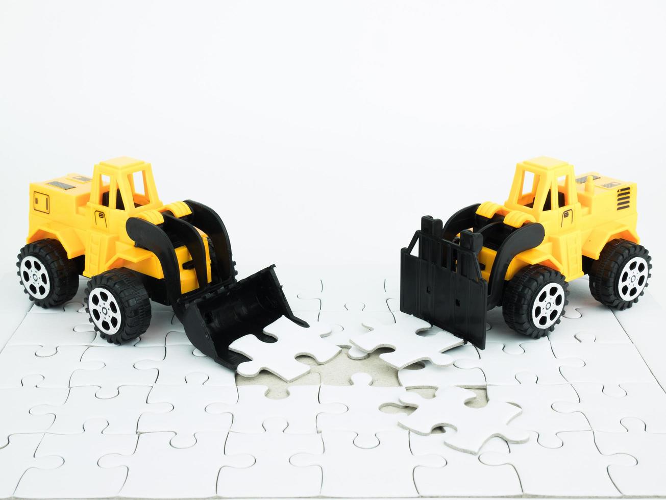 Bulldozer jouet et chariot élévateur avec puzzle sur fond blanc photo