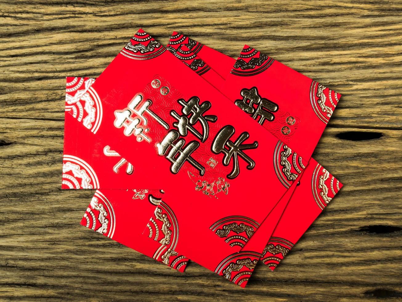 enveloppe rouge sur fond en bois avec février pour cadeau nouvel an chinois. texte chinois sur enveloppe signifiant joyeux nouvel an chinois photo