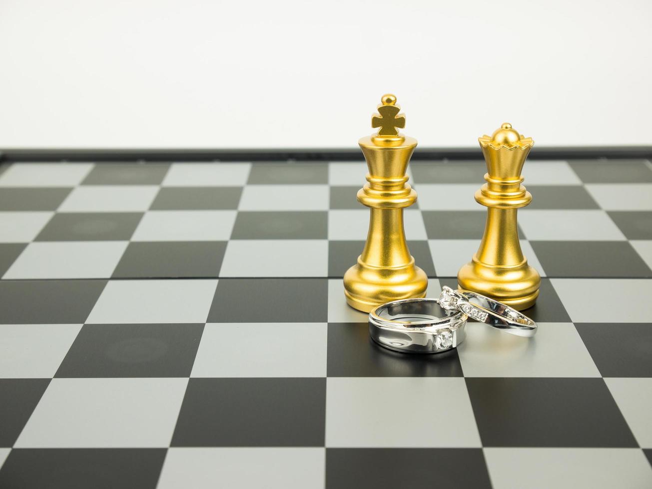 bague en diamant avec échecs roi et reine sur le plateau, concept de mariage. photo