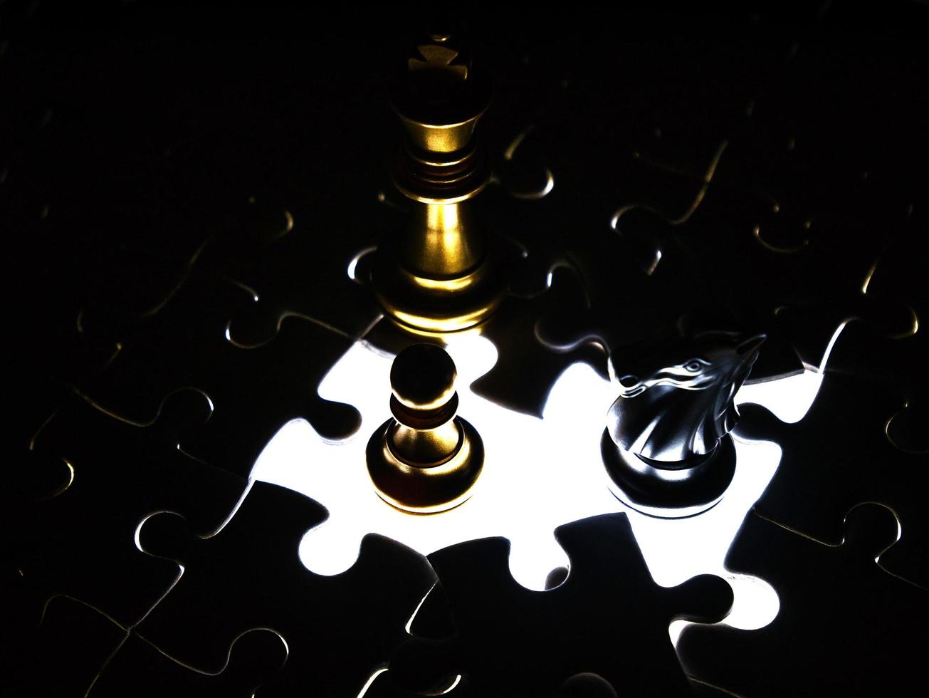 pièce d'échecs en or et en argent sur fond de puzzle, concept d'entreprise photo