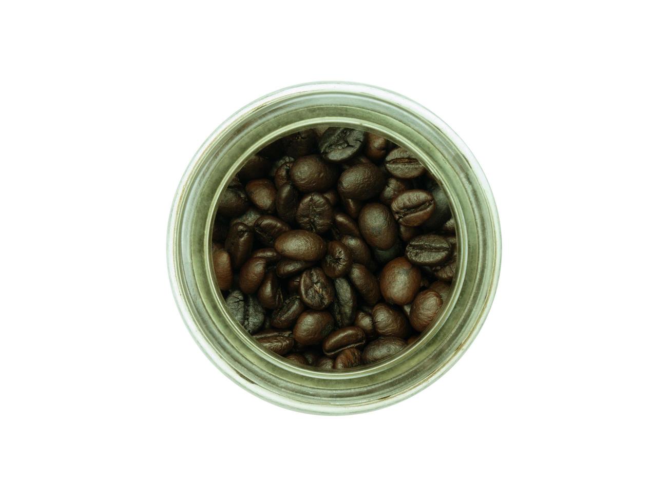 grains de café dans un bocal en verre isolé sur fond blanc, gros plan photo