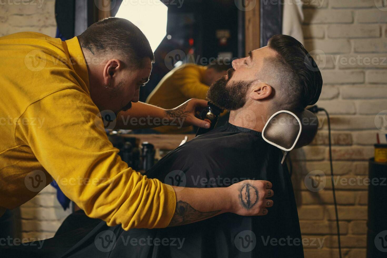 client avec gros noir barbe pendant barbe rasage dans coiffeur magasin photo