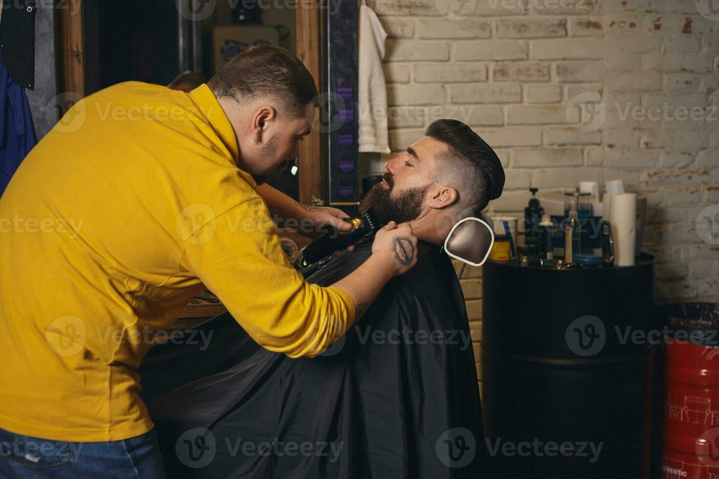 client avec gros noir barbe pendant barbe rasage dans coiffeur magasin photo