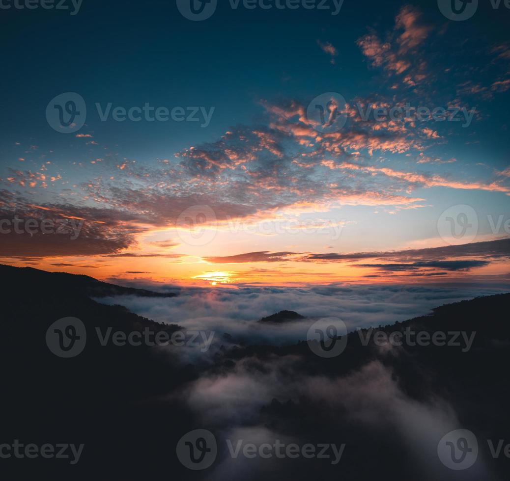 le soleil se lève dans la brume et les montagnes le matin photo