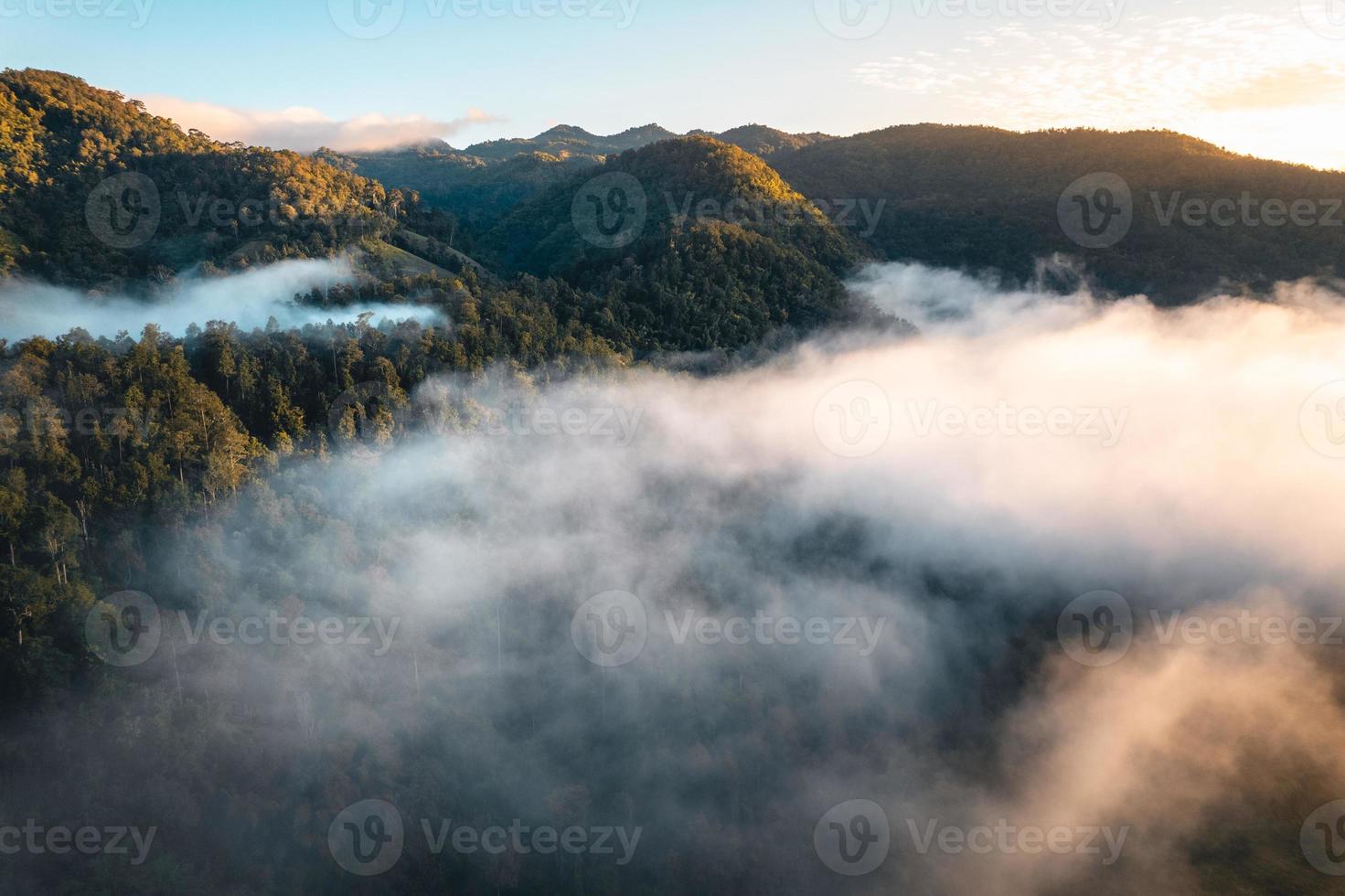 le soleil se lève dans la brume et les montagnes le matin photo