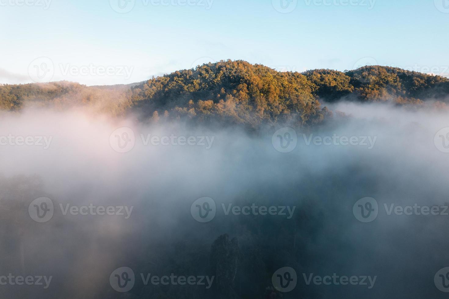 le soleil se lève dans la brume et les montagnes le matin photo