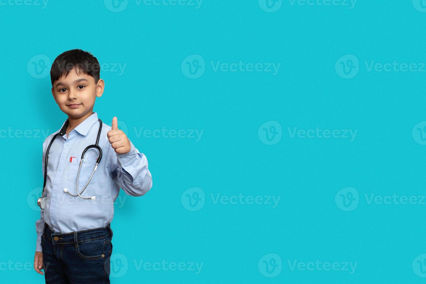 médecin garçon enfant souriant avec des lunettes fond uni. doc masculin en chemise blanche faisant le pouce levé. concept de médecine de santé de santé. maquette copie espace photo