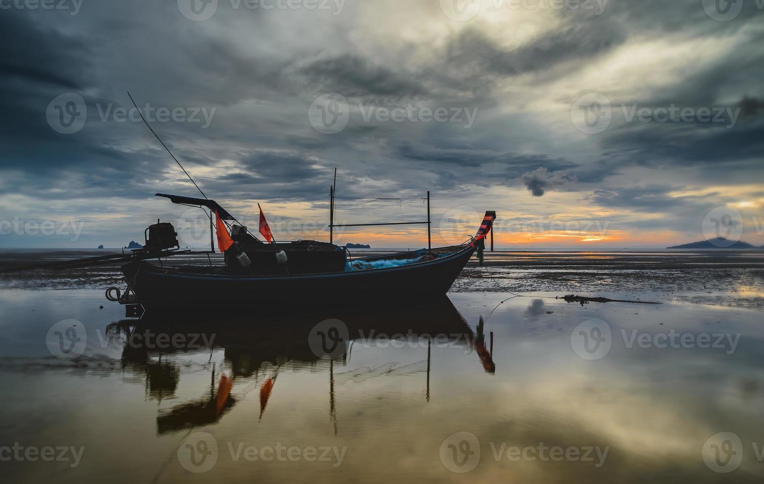 bateau de pêche en bois avec un ciel coucher de soleil à faible éclairage. photo