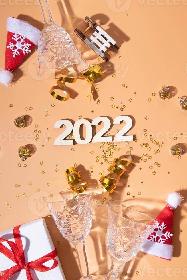 plat festif du nouvel an avec des numéros 2022 et des ombres dures avec des lunettes et un décor brillant photo