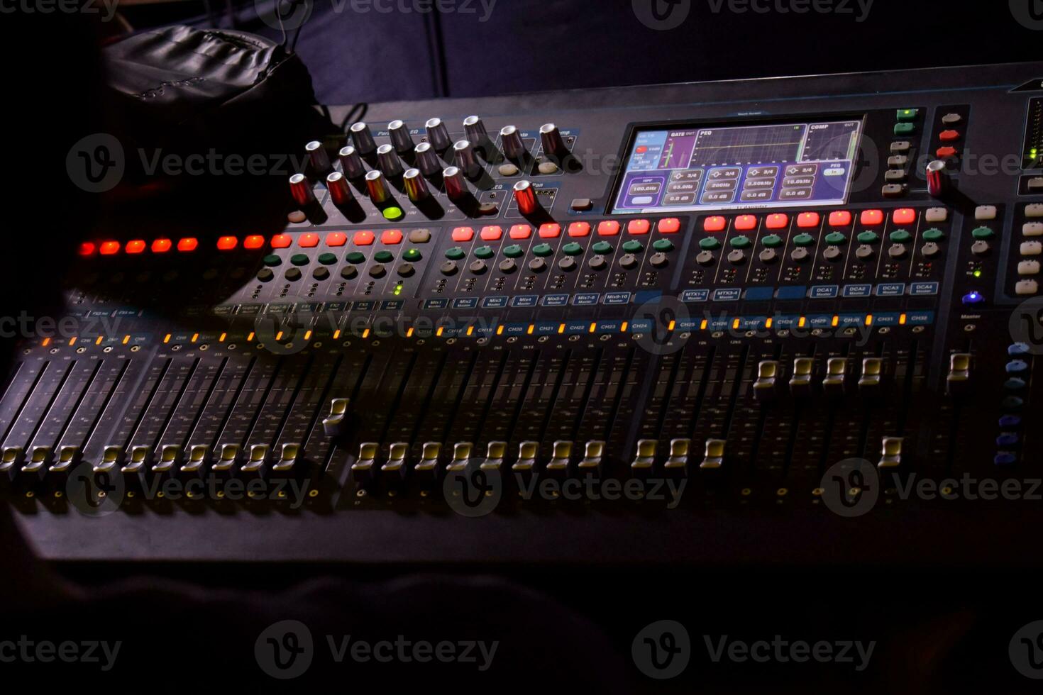 une homme surveillance curseurs sur le l'audio console. photo