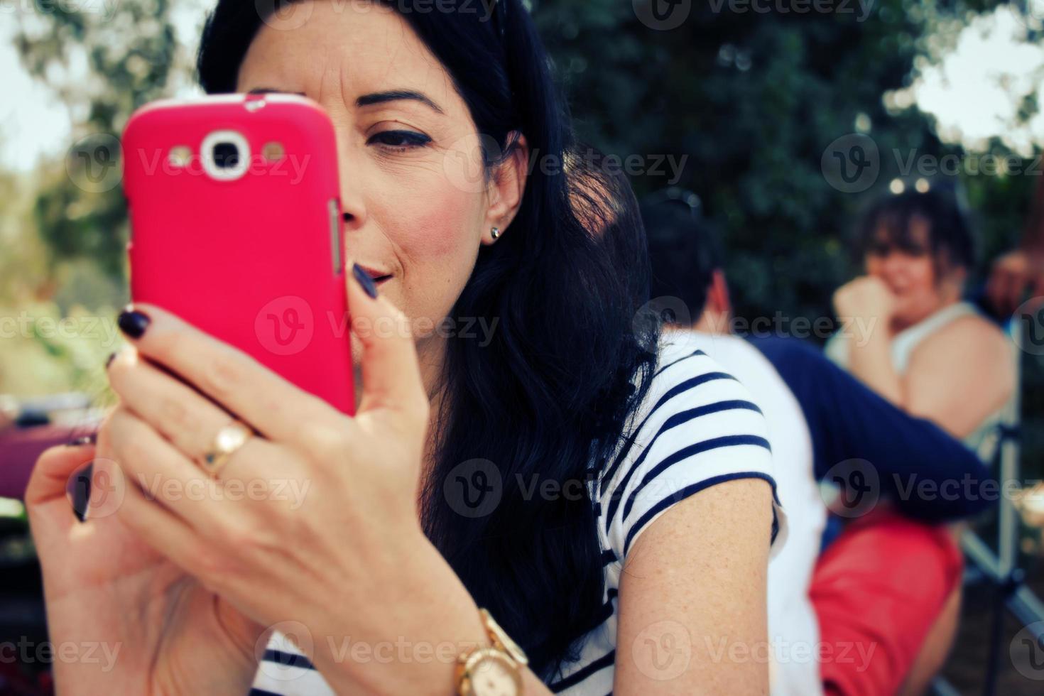 femme prenant une photo avec son téléphone portable