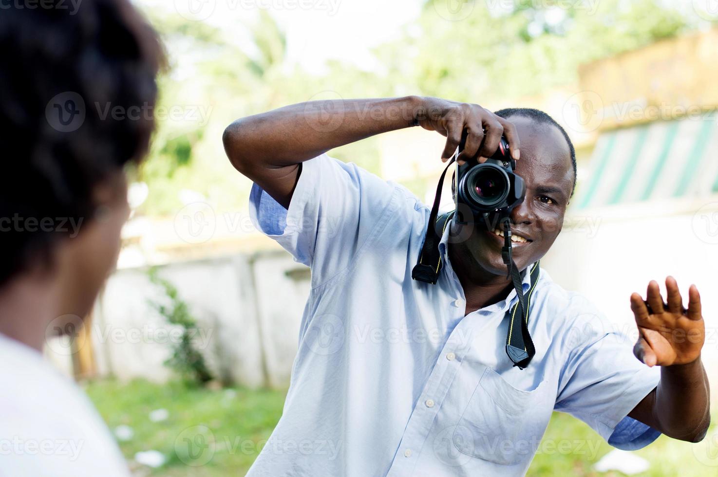 jeune photographe prenant la pose devant son modèle photo