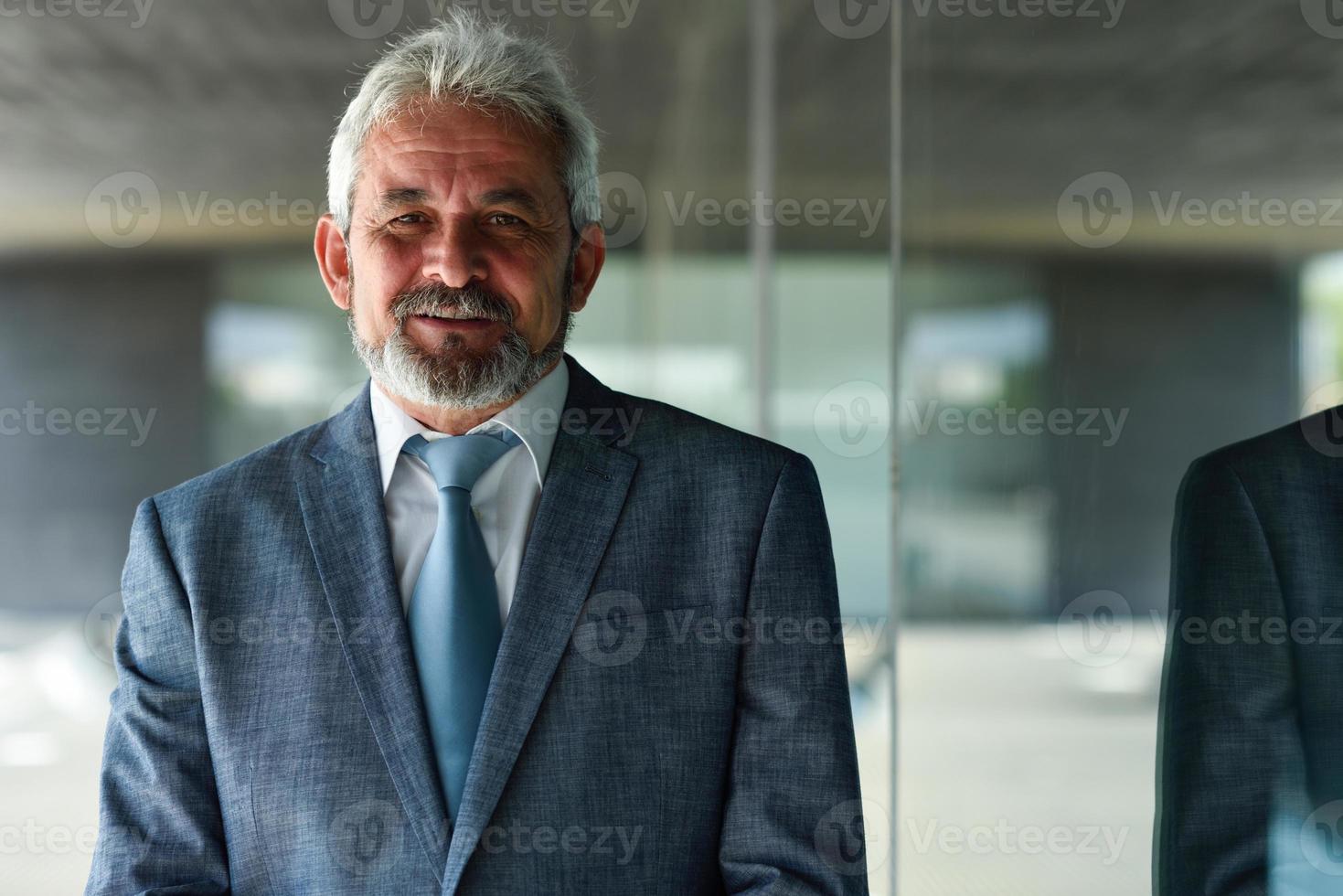 homme d'affaires senior à l'extérieur d'un immeuble de bureaux moderne. photo