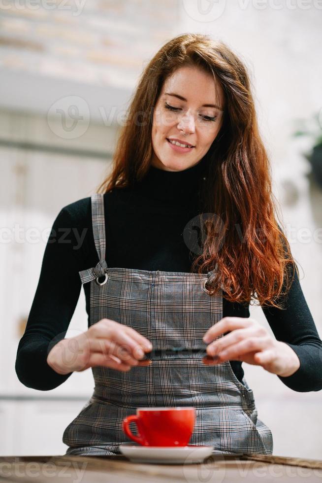 femme rousse avec des cheveux gris utilisant un smartphone dans un café. photo