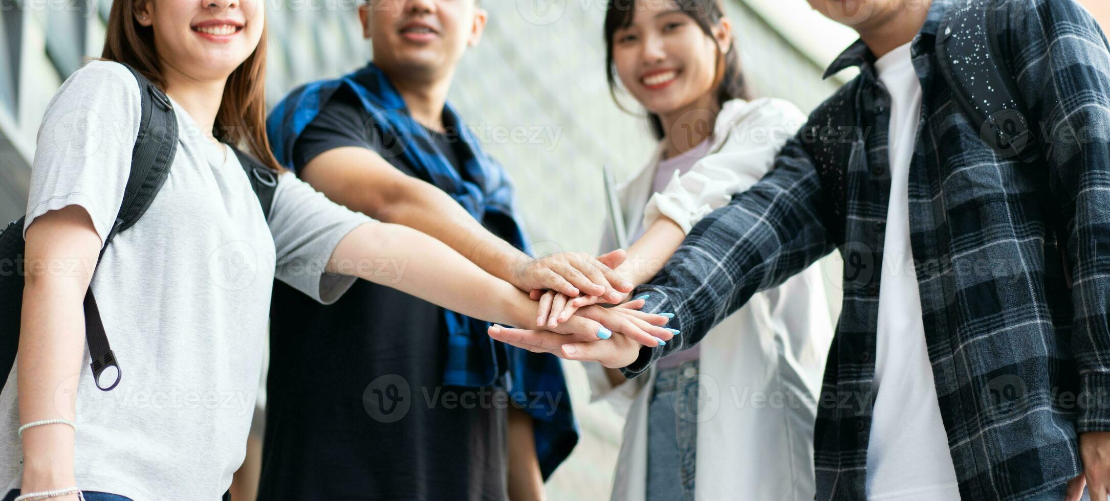 groupe de de bonne humeur Jeune asiatique entrepreneurs joindre mains ensemble à célébrer, excité Succès pour réalisations obtenu. premier cycle élèves célébrer Succès après fin projet, travail en équipe concept photo