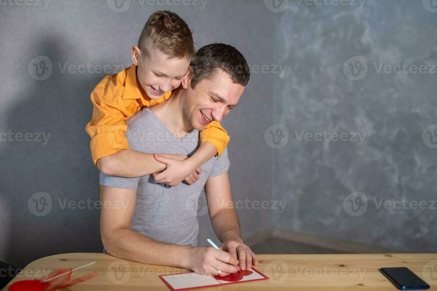 une content garçon câlins le sien papa . fabrication une la Saint-Valentin journée carte avec une cœur photo