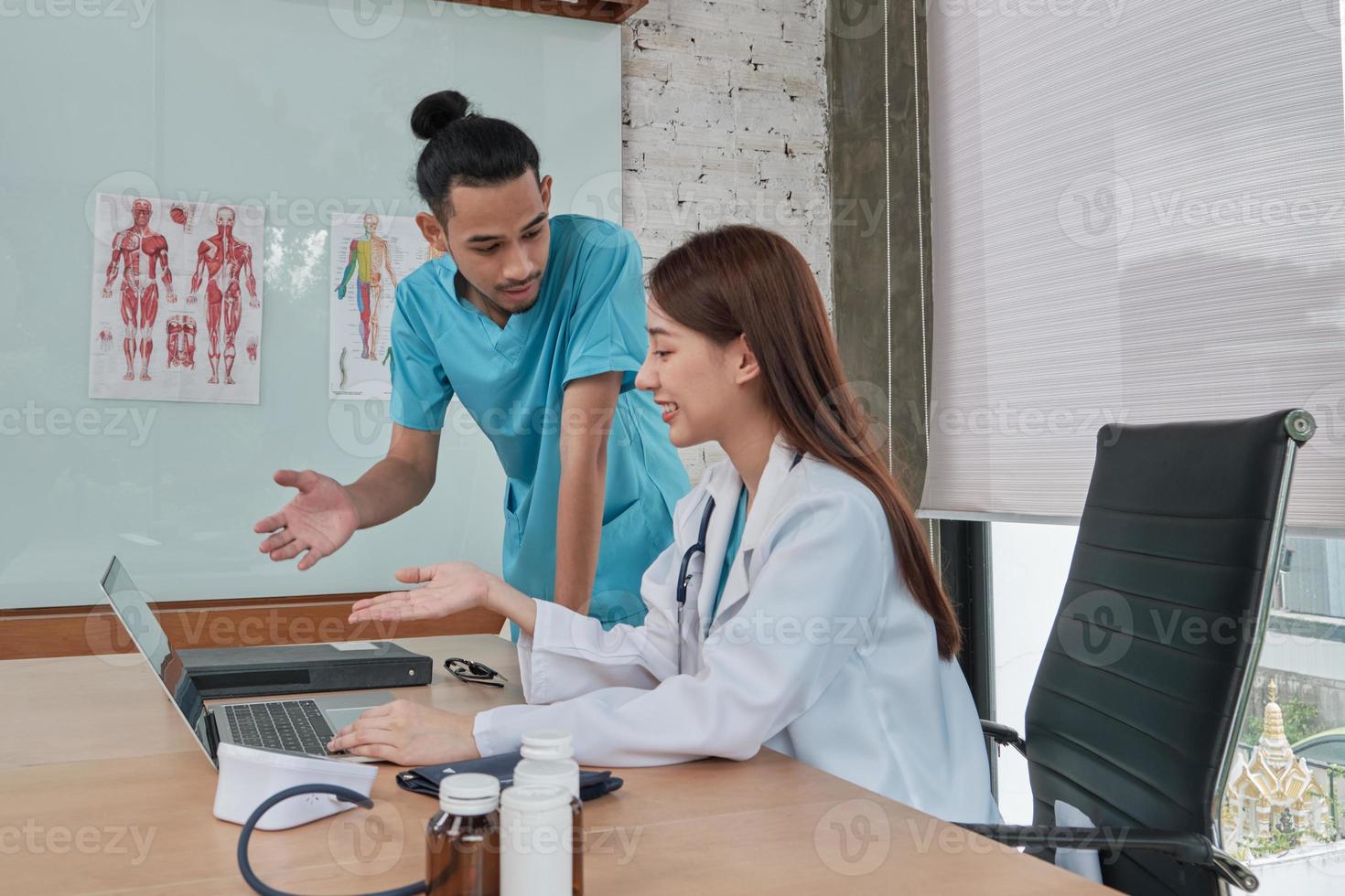 partenaires de l'équipe de soins de santé. deux jeunes médecins asiatiques en uniforme sont des collègues discutant des médicaments dans le bureau de la clinique de l'hôpital. les spécialistes sont des experts et des professionnels. photo