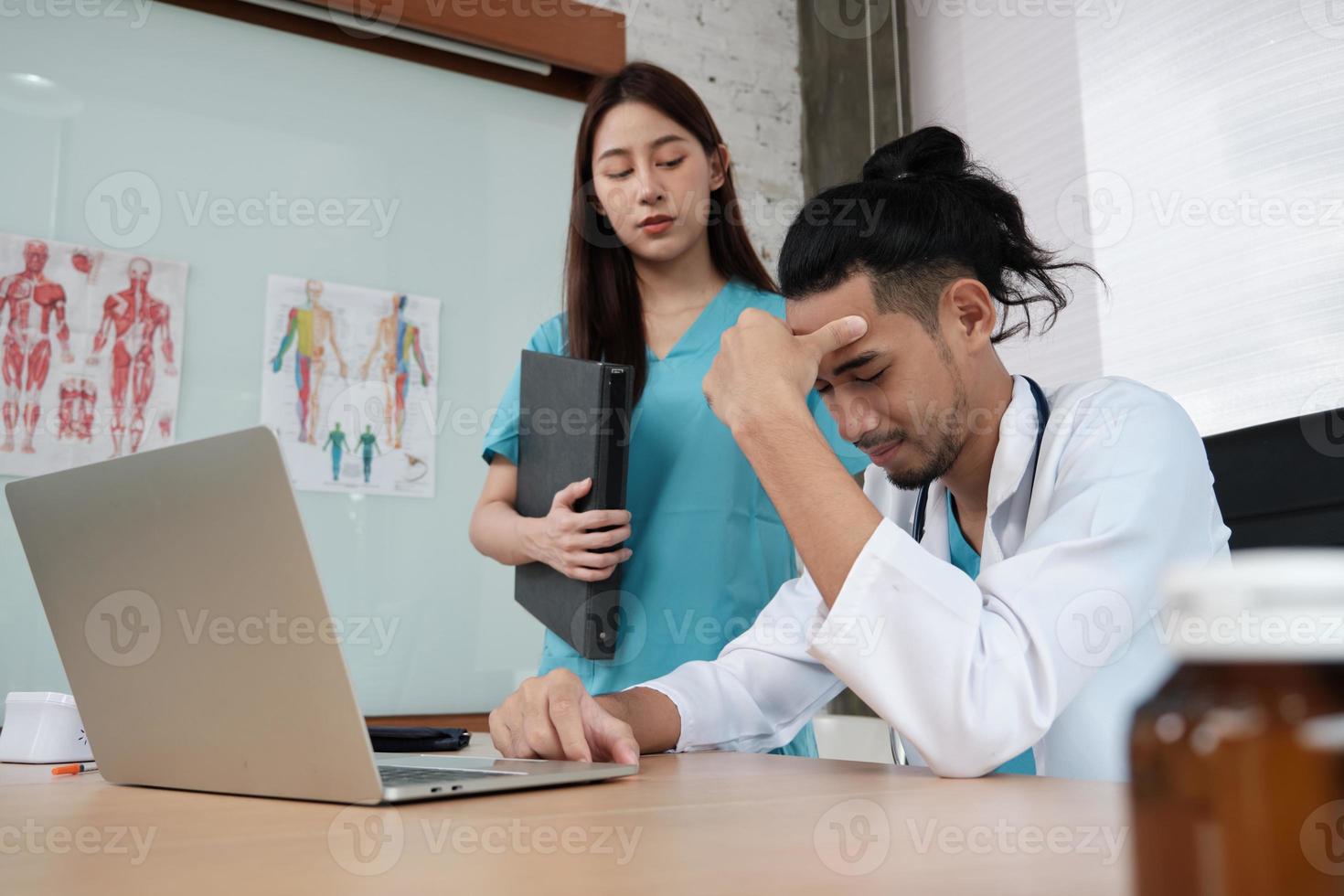 une jeune collègue encourage et réconforte son partenaire médecin d'origine asiatique qui est triste et stressé au travail, au bureau de la clinique de soins de santé et de traitement médical de l'hôpital. photo