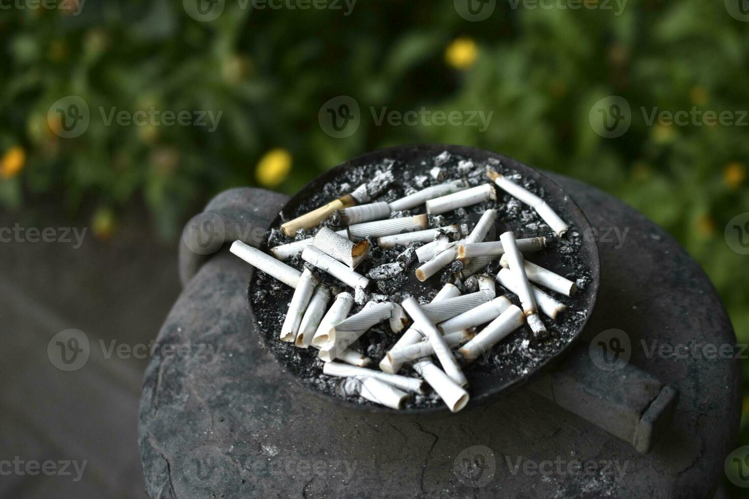 un cendrier pour cigarette mégots sur le rue. fumé cigarettes dans le poubelle. photo