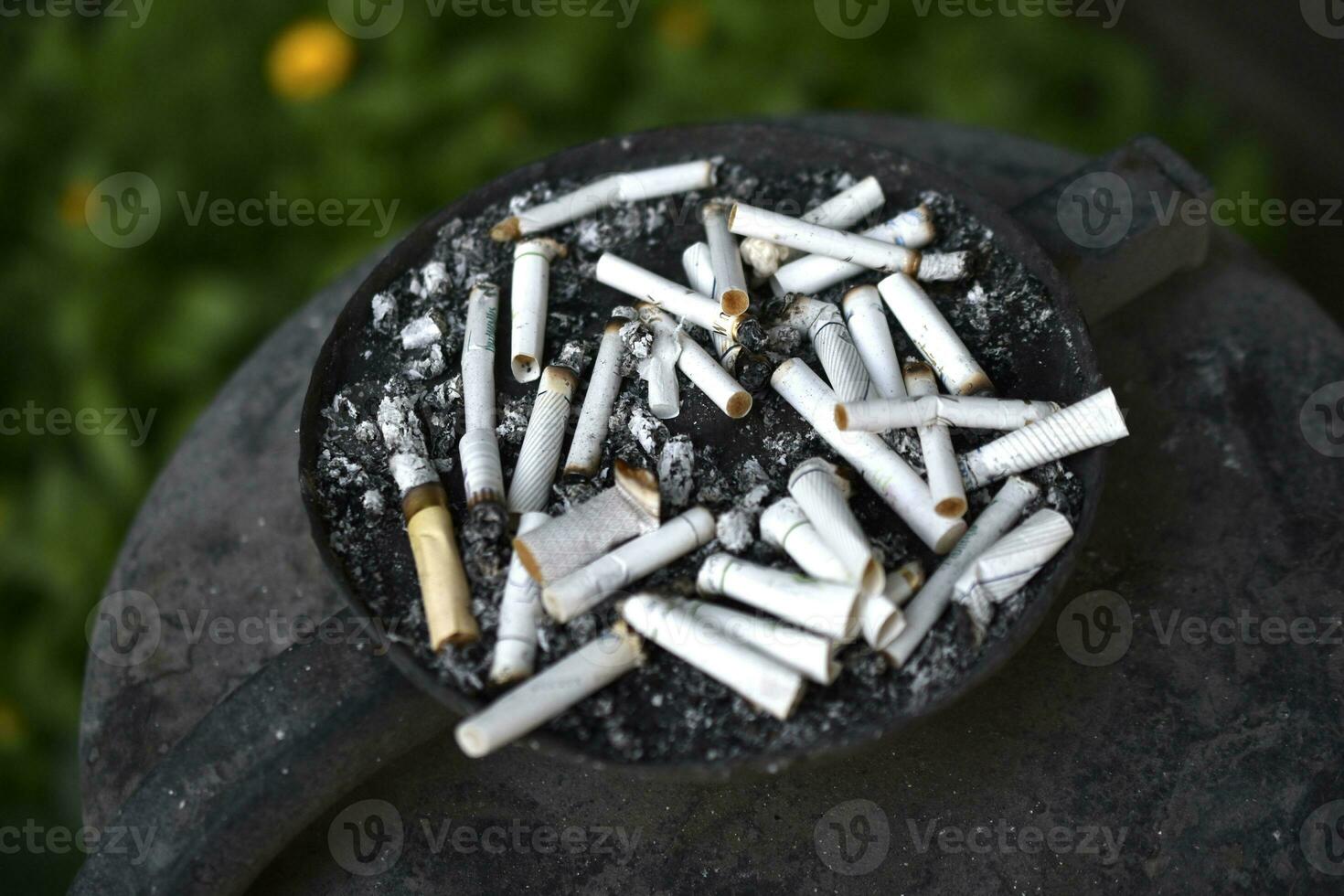 un cendrier pour cigarette mégots sur le rue. fumé cigarettes dans le poubelle. photo