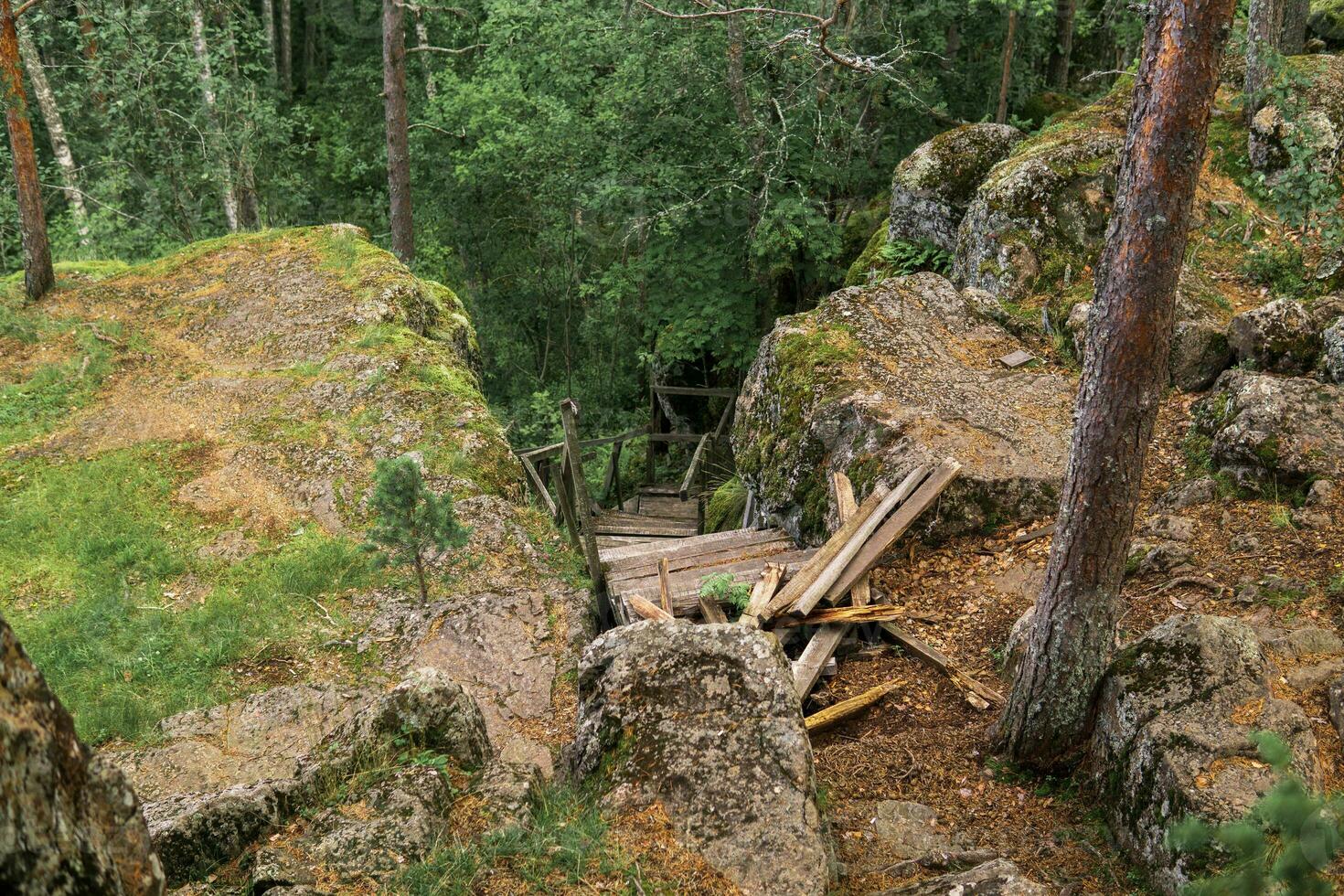 ruiné en bois escalier sur un abandonné chemin dans une Montagne forêt photo