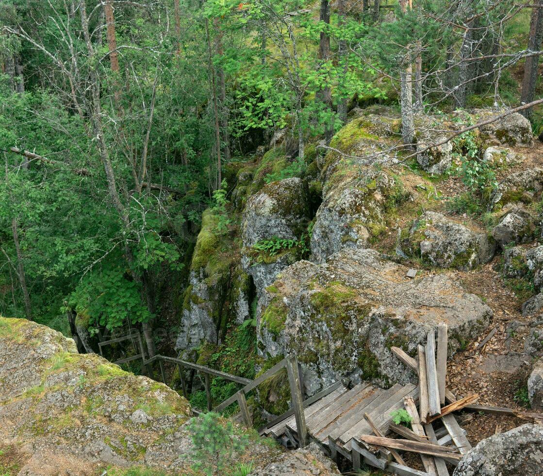 ruiné en bois escalier sur un abandonné chemin dans une Montagne forêt photo