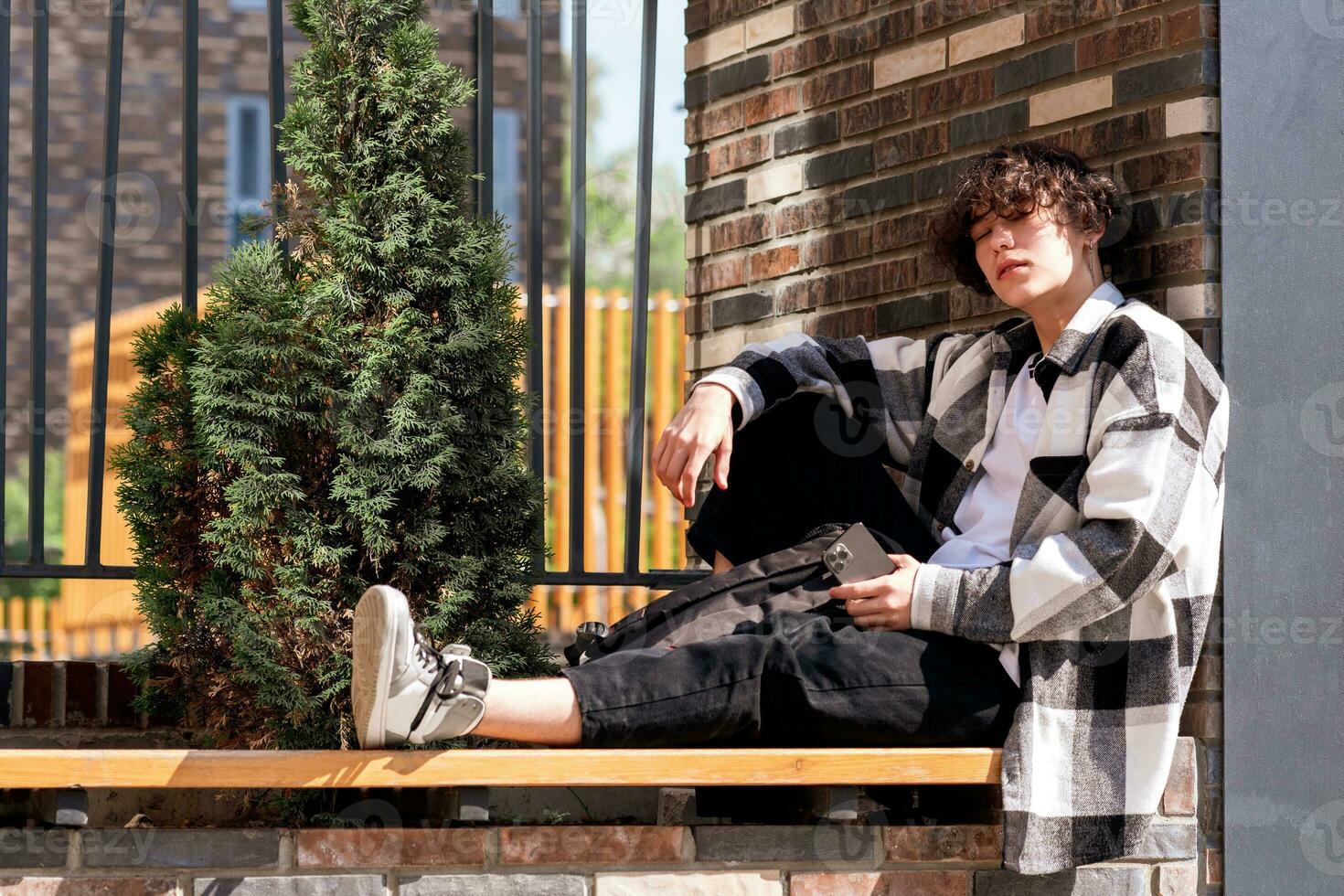 Jeune homme est assis détendu sur une ville banc photo