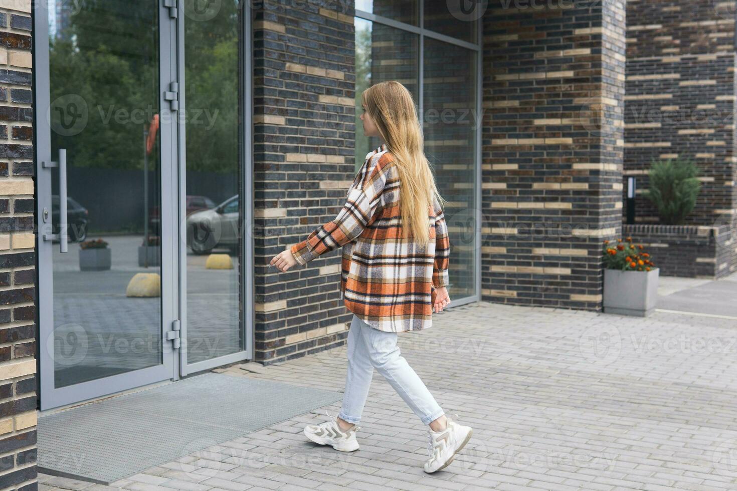 Jeune femme entre dans le porte de une ville bâtiment photo