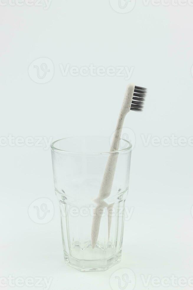 brosse à dents dans verre sur blanc Contexte. dentaire hygiène. photo