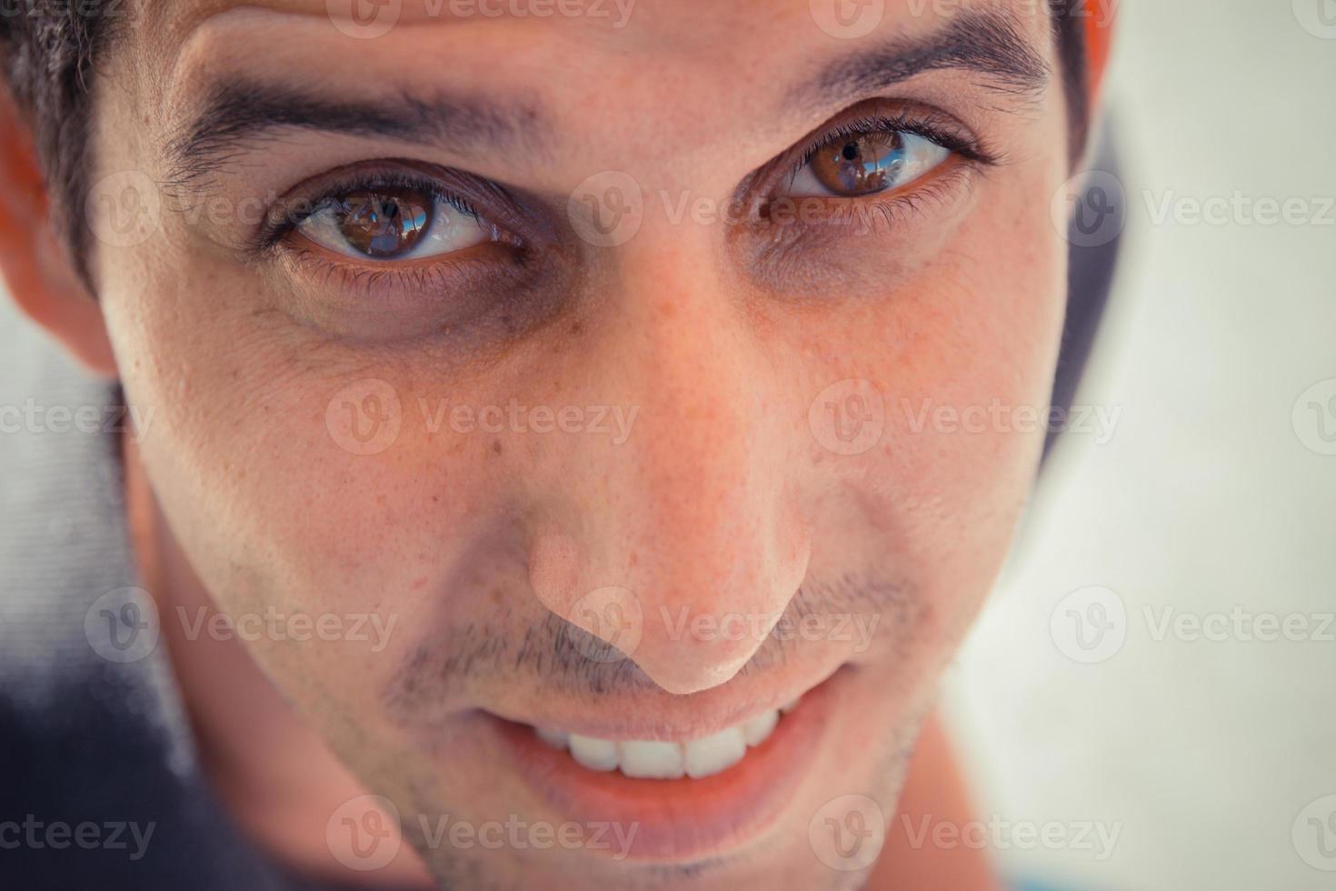 gros plan vue de dessus portrait d'un jeune homme regardant la caméra avec un visage souriant photo