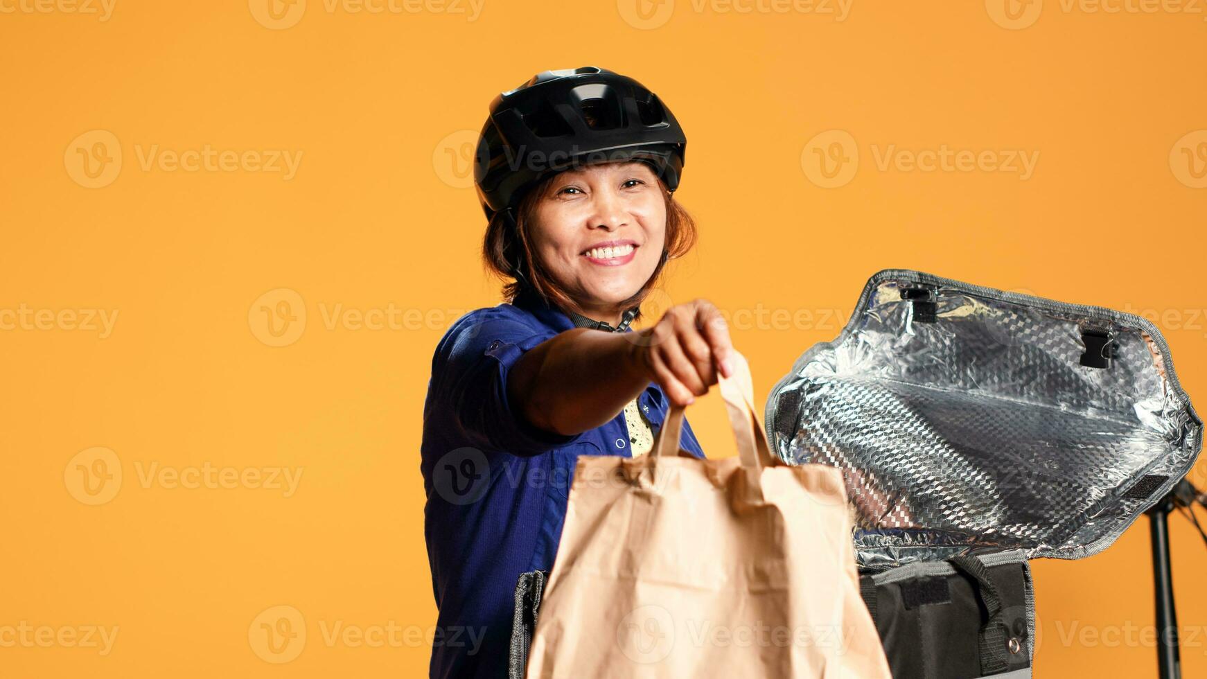 proche en haut coup de courrier en arrivant à client adresse, prise repas sac en dehors de thermique sac à dos. content bipoc bicyclette cavalier livrer le déjeuner à client, isolé plus de studio Contexte photo