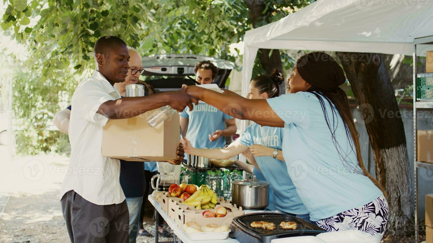 diverse groupe distribuer contribution des boites à ceux dans avoir besoin à une sans abri et réfugié abri. multiracial bénévoles partager essentiel et fournir soutien par une non lucratif nourriture banque. portable. photo