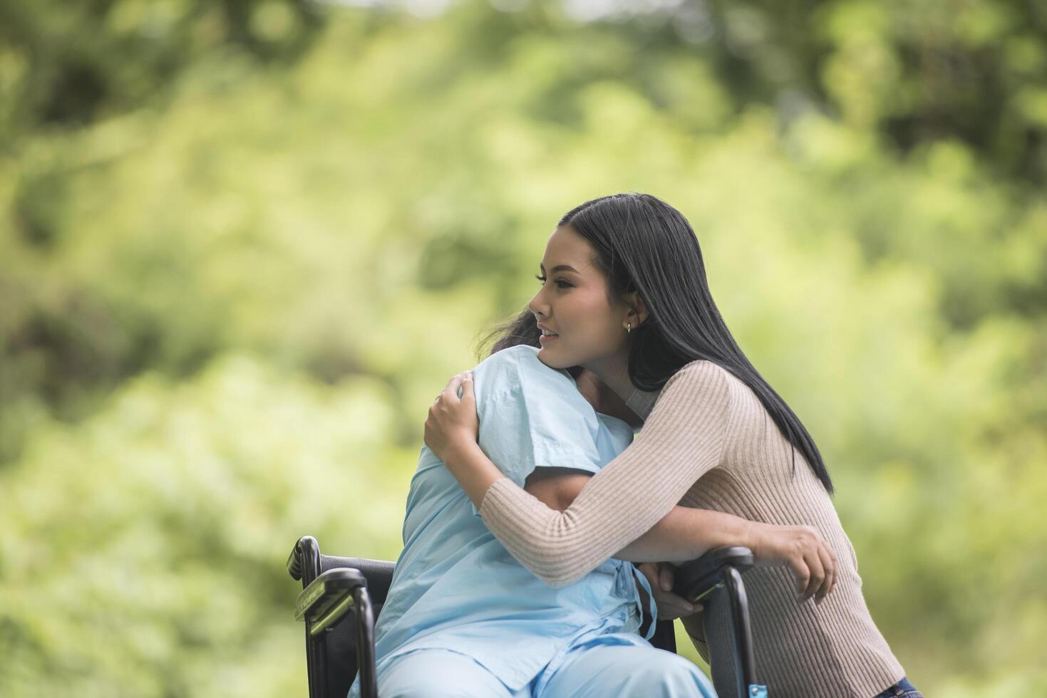 petite-fille parlant avec sa grand-mère assise sur un fauteuil roulant, concept joyeux, famille heureuse photo