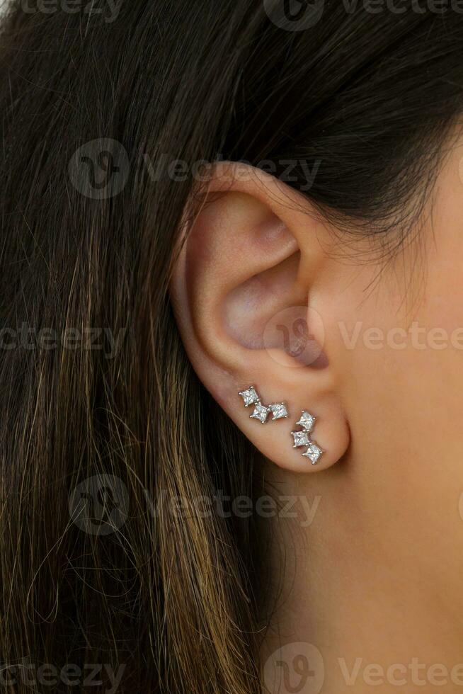 femme portant magnifique Goujon des boucles d'oreilles avec zircone. photo