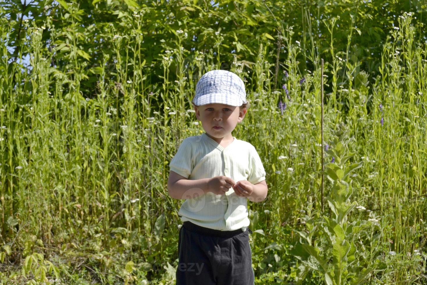 Beau petit garçon avec un photographe de pose de visage d'enfant photo