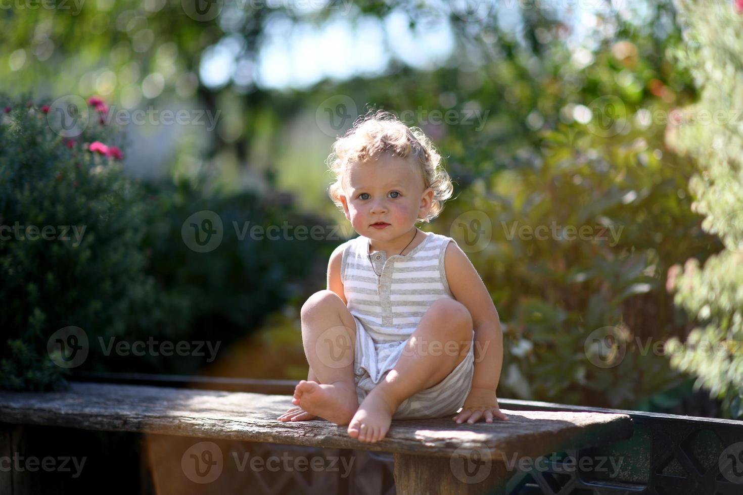 Beau petit garçon dans le jardin de l'enfant photographe posant photo