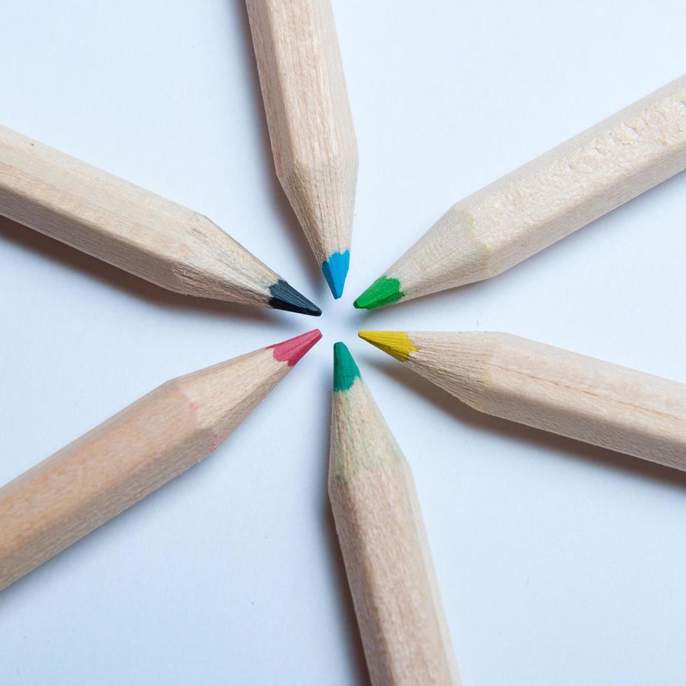 crayons en bois colorés disposés en forme d'étoile radiale symétrique, vus d'en haut. fond blanc. concept de retour à l'école. photo
