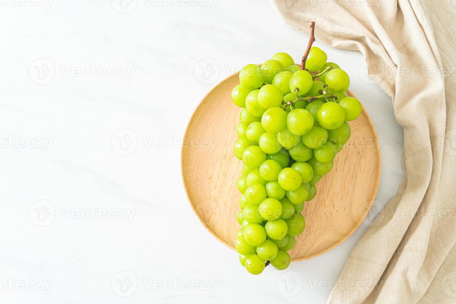 raisin vert frais sur plaque de bois photo