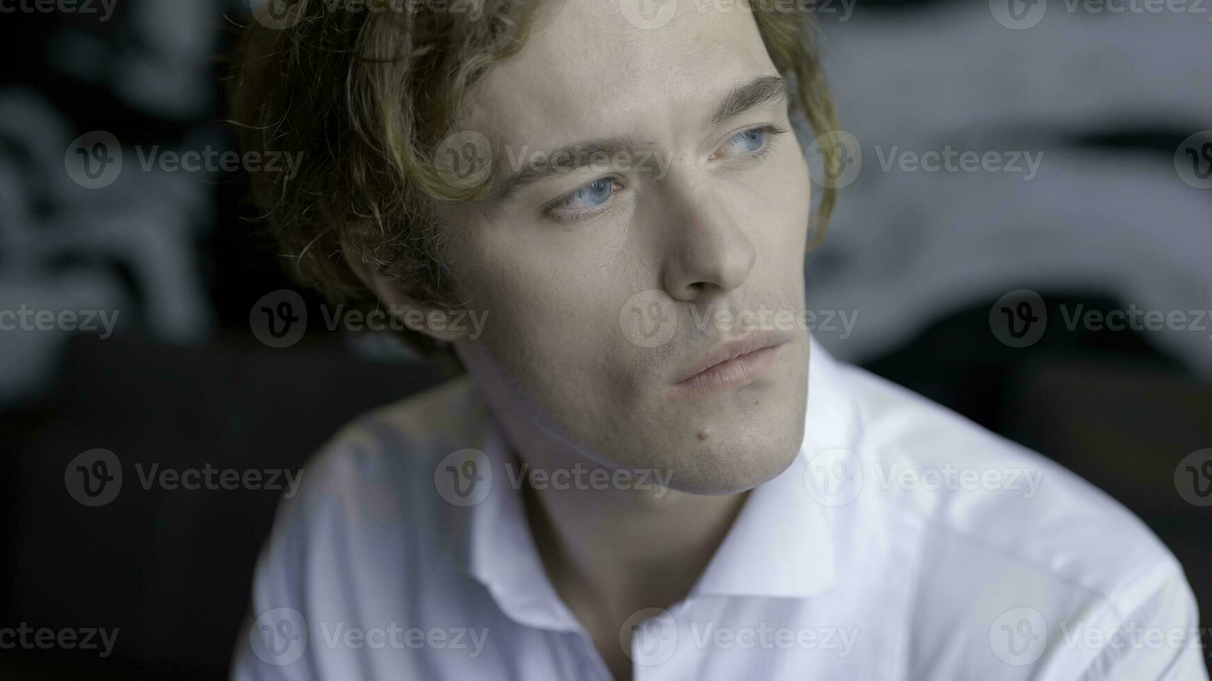 une Beau homme avec longue cheveux est repos. action.le Beau jeune marié est séance repos et en buvant une tasse de café dans le pièce sur le canapé. photo