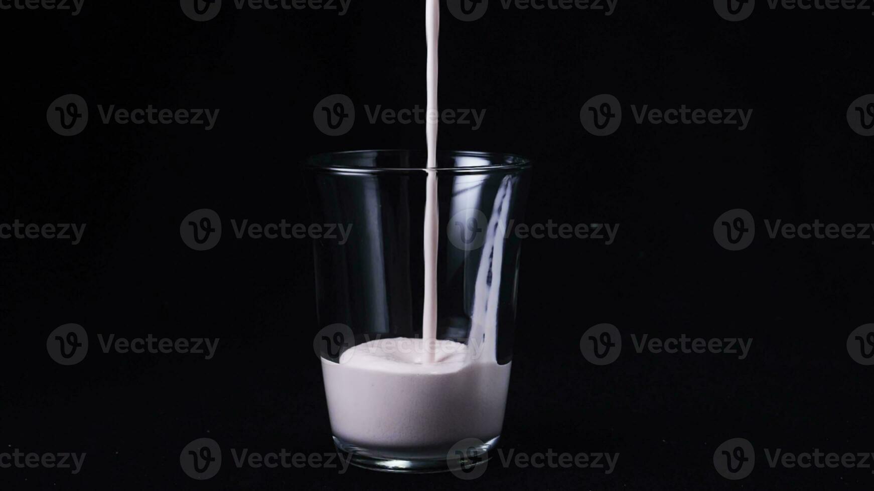 fermer de nettoyer verre rempli par fraise Milk-shake. Cadre. isolé sur noir photo